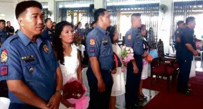  ?? JINKY CABILDO ?? SIX QUEZON City police officers reaffirm their commitment to their spouses in a mass renewal of wedding vows sponsored by top-ranking QC police officials at Camp Karingal, Quezon City.