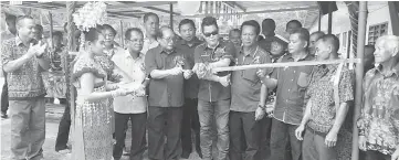  ??  ?? Rayong (fifth right) cuts the ribbon to mark the occasion, as Nyallau (sixth right) and others look on.