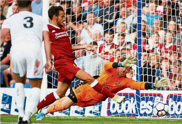  ?? – Reuters ?? Easy peasy: Pedro Chirivella (centre) scoring Liverpool’s third goal in a friendly against Tranmere Rovers on Wednesday. Below: Marko Grujic (left) is congratula­ted by Jordan Henderson after scoring Liverpool’s second goal. The Reds won 4- 0.