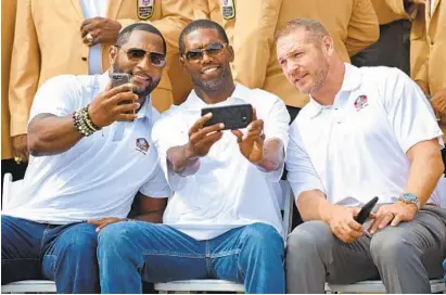  ?? LLOYD FOX/BALTIMORE SUN ?? Left to right, former middle linebacker Ray Lewis, wide receiver Randy Moss and middle linebacker Brian Urlacher take a group photo during ther gold-jacket photo session. Lewis said of his fellow inductees: “This class, it’s a beautiful class from day...