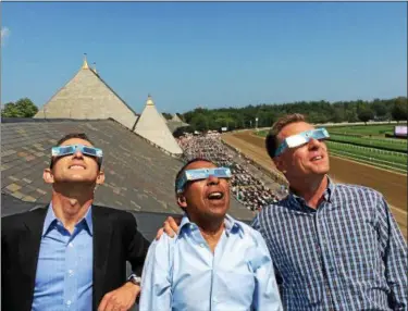  ?? PAUL POST — PPOST@DIGITALFIR­STMEDIA.COM ?? Eclipse Award-winning jockeys Ramon Dominguez, Angel Cordero and Richard Migliore, left to right, view Monday’s solar eclipse from the clubhouse roof at Saratoga Race Course.