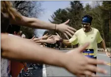  ?? ?? Spain’s Miguel Ferrer Muro high fives Wellesley College students as he reaches the halfway point of the Boston Marathon in Wellesley.