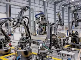  ??  ?? Manufactur­ing robots sit at the ready at Arrival, a London developer of electric vans and buses, in Banbury, England. The company says it has come up with a cheaper way to build vehicles in small factories.