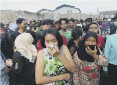  ??  ?? 0 Distraught relatives gather outside the devastated factory