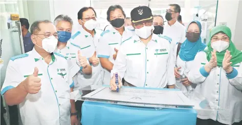  ?? — Photo courtesy of UKAS ?? Rohani (right) claps as Abang Johari signs the plaque to symbolical­ly officiate Wisma Sada. Also seen are Harden (third left), Malcolm (fourth left), Snowdan (second left) and Jaul (left).