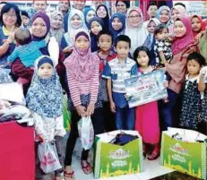  ??  ?? SKUAD PERKESO Prihatin Tawau bergambar kenangan bersama 12 anak yatim yang terpilih menerima sumbangan dalam Program Prihatin Perkeso Jom Raye.