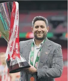  ??  ?? Lee Johnson with the Papa John’s Trophy. Picture by Getty Images