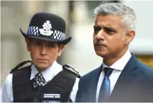  ?? (Clodagh Kilcoyne/Reuters) ?? LONDON MAYOR Sadiq Khan listens as Metropolit­an Police Commission­er Cressida Dick speaks yesterday at the scene of Saturday night’s attack on London Bridge and Borough Market.