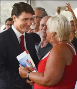  ?? GARY NYLANDER/The Daily Courier ?? Prime Minister Justin Trudeau welcomes one of 60 new Canadian citizens during a citizenshi­p ceremony Wednesday at Stuart Park.