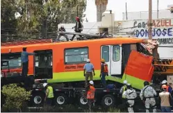  ?? AP PHOTO/MARCO UGARTE ?? Workers remove a damaged subway car after it was lowered, with the help of a crane, from a collapsed elevated section of the metro in Mexico City, on Tuesday.