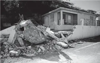  ?? Carlos Giusti / Associated Press ?? A big rock sits amid rubble of a wall it destroyed after it rolled down a cliff during Saturday’s 5.9magnitude aftershock in Guanica, Puerto Rico, the strongest one since Tuesday’s earthquake.