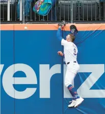  ?? MARY ALTAFFER/AP ?? New York Mets outfielder Brandon Nimmo hit the wall trying to catch a two-run home run by Kansas City Royals’ Salvador Perez during the fourth inning of a baseball game on Saturday in New York.