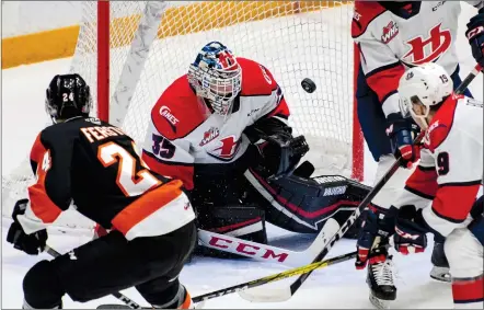  ?? NEWS PHOTO RYAN MCCRACKEN ?? Lethbridge Hurricanes goaltender Carl Tetachuk makes a save on Medicine Hat Tigers forward Ashton Ferster during a Western Hockey League game at Co-op Place on Friday.