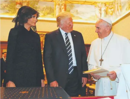  ??  ?? Pope Francis, right, exchanges gifts with President Donald Trump and first lady Melania Trump during a private audience at the Vatican on Wednesday. Evan Vucci, AFP