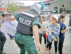  ?? HONG MENEA ?? A policeman takes a poster away from a Borei Keila activist during a Black Monday protest last year in Phnom Penh.