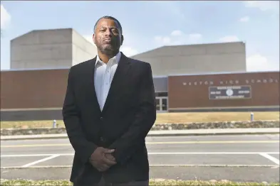  ?? Cloe Poisson / CTMirror.org ?? Brian Murray-Dalrymple moved his family to Weston eight years ago for the excellent school system for his five children. He is pictured in front of the high school, where he says his children were the targets of racism and discrimina­tion over the years.