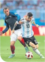  ??  ?? Messi holds off France’s Antoine Griezmann