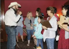  ?? PAT EATON-ROBB — THE ASSOCIATED PRESS ?? Actor Dan Russell, left, portraying the character Arkansas from Mark Twain’s book “Roughing it,” responds to a question from 10-year-old Emma Connell, center, of Arizona during a “Clue” tour at the Mark Twain House in Hartford, Conn. The tour allows...