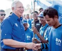  ?? AFP ?? Malaysian Prime Minister Najib Razak shakes hands with his supporters during a campaign event ahead of the upcoming general elections in Pekan, Pahang, on Sunday. —