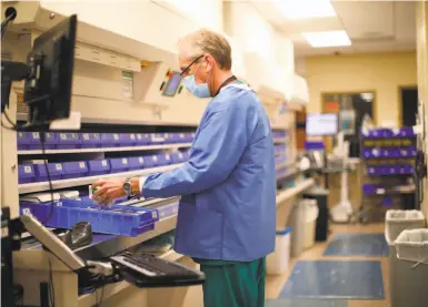  ?? Yalonda M. James / The Chronicle ?? Pharmacy technician Joel McDowell works in the pharmacy at Alta Bates Summit Medical Center in Oakland.