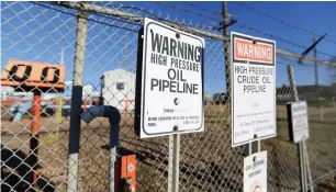  ?? — Reuters ?? Signs warning of oil pipelines are seen outside facilities near Alberta, Canada.