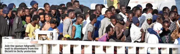  ??  ?? Join the queue: Migrants wait to disembark from the Diciotti in Sicily yesterday