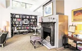  ??  ?? Clerestory windows and a dramatic fireplace mantel, plus plenty of purple details, mark the living room. The William Anzelone painting that Elias’s husband bought for her after an early date is on the right.