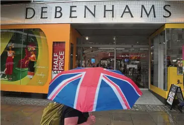  ??  ?? Tough time: A shopper walks past a Debenhams store in central London. Consumers have struggled this year as faster inflation – reflecting the pound’s decline since the Brexit vote – puts a strain on their pockets. — Reuters