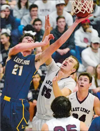  ?? SARAH GORDON/THE DAY ?? Ledyard’s Trevor Hutchins (21) puts up a shot over East Lyme’s Jacob Peters (55) during Thursday’s ECC Division I showdown where Hutchins had 28 points and 25 rebounds in a 71-55 win.