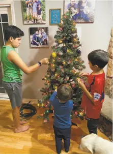 ?? CLAIRE THOMPSON ?? The Thompson family ( from left to right: Will, 11, Ben, 3, and Jack, 7) decided to decorated an artificial Christmas tree two weeks before Thanksgivi­ng in their playroom.