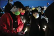  ?? JOE LAMBERTI / CAMDEN COURIER-POST ?? People gather for a vigil Wednesday in Philadelph­ia to mourn and confront the rising violence against Asian Americans. The vigil was held after a shooting in Atlanta that killed eight people.