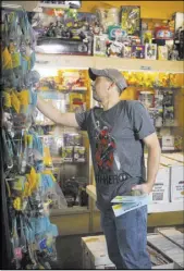  ??  ?? A customer at a Vintage Stock store in Kansas City, Mo., looks through a selection of toys and figures. Vintage Stock is a subsidiary of Live Ventures. Vintage Stock