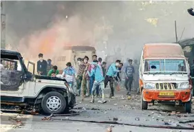  ??  ?? Protestors hurl brickbats as smoke billows out of burning cars during 'Bharat Bandh' against the alleged 'dilution' of Scheduled Castes/scheduled Tribes act, in Muzzaffarn­agar on Monday