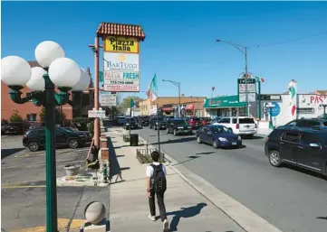  ?? JOHN J KIM/CHICAGO TRIBUNE PHOTOS ?? A man walks through a business corridor with several Italian-themed restaurant­s and stores in the 3400 block of North Harlem Avenue on April 19 in Chicago.