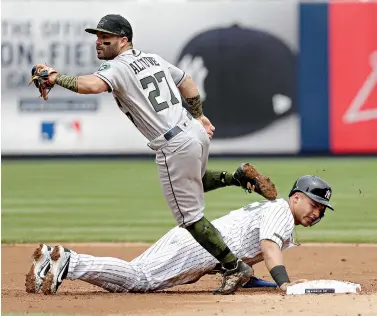  ?? AP Photo/Seth Wenig ?? ■ New York Yankees’ Gleyber Torres, right, reacts after he is caught off base by Houston Astros second baseman Jose Altuve during the second inning Monday at Yankee Stadium in New York.