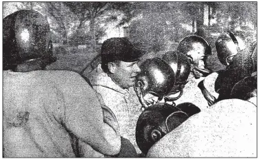  ?? Democrat- Gazette fi le photo ?? Little Rock Central High School’s football team coached by Wilson Matthews ( center) was 12- 0 in 1957, earning a share of the mythical high school national title despite the school’s campus being rocked by racial turmoil.