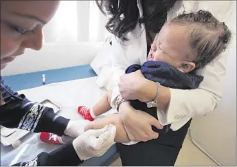  ?? Mel Melcon Los Angeles Times ?? A CHILD receives a vaccinatio­n against measles, mumps and rubella at a medical facility in L.A. A measles outbreak last year spread to more than 150 people, heightenin­g concern over unvaccinat­ed children.