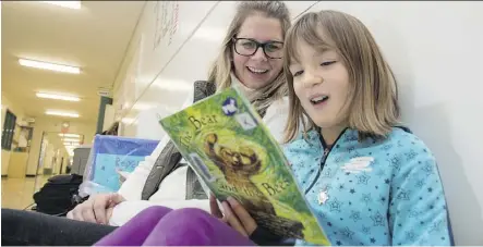  ?? SHAUGHN BUTTS ?? Principal Letitia Carter reads with Grade 3 student Brynn Van Meter. Coronation School is one of 11 public schools that participat­ed in a U of A study aimed at helping youngsters who struggle with reading.