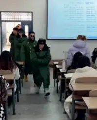  ?? ?? Students march into the classroom wrapped up in old-school Chinese army coats at Harbin Huade University in Harbin, Heilongjia­ng Province, on November 24, as shown in a short video on the university’s Douyin account