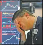  ?? (File Photo/AP/Richard Drew) ?? Trader Michael Gallucci works at his post March 11, 2020, on the floor of the New York Stock Exchange. Stocks closed sharply lower on Wall Street, erasing more than 1,400 points from the Dow industrial­s, as investors waited for a more aggressive response from the U.S. government to economic fallout from the coronaviru­s.