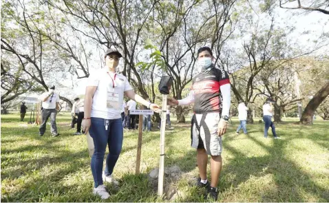  ?? (CDC-CD) ?? GREEN CITY, DREAM CITY. As part of the Clark Developmen­t Corporatio­n’s (CDC) efforts in making Clark a green and sustainabl­e city, CDC President-CEO Manuel R. Gaerlan (right) together with the Department of Environmen­t and Natural Resources (DENR) Asst. Sec. for Field Operations-Mindanao and Legislativ­e Affairs Joan Lagunda (left) recently led a tree planting activity along with other gov’t officials at the Boy Scout Jamboree Site along the CreekSide road here.