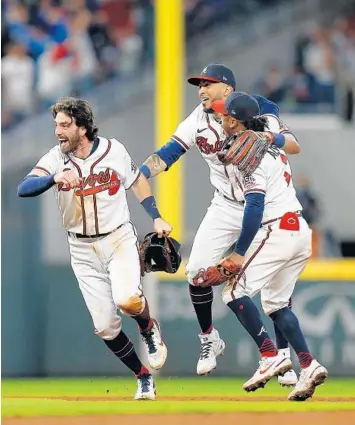  ?? MICHAEL ZARRILLI/GETTY ?? Dansby Swanson, Eddie Rosario and Ozzie Albies celebrate after the Braves beat the Dodgers 4-2 on Saturday to advance to the World Series. The Braves will take on the Astros, beginning Tuesday night in Houston.