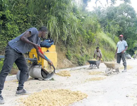  ?? KENYON HEMANS/PHOTOGRAPH­ER ?? Workmen carrying out rehabilita­tion work on a section of the Mount Olive main road in St Andrew West Rural on Monday.