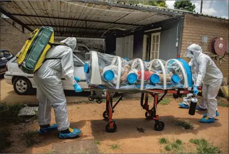  ?? Alet Pretorius Gallo Images ?? HEALTHCARE WORKERS move a COVID-19 patient Jan. 15 in Pretoria, South Africa. A new viral strain has emerged from the country.