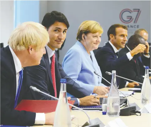  ?? SEAN KILPATRICK/ THE CANADIAN PRESS ?? Prime Minister Justin Trudeau, second from left, sits between British Prime Minister Boris Johnson, left, and German Chancellor Angela Merkel at the G7 Summit in Biarritz, France in 2019. Canada has become the worst performer of all G7 nations on climate change since the landmark Paris Agreement was adopted, a report says.