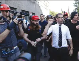  ?? Associated Press photo ?? Gavin McInnes is surrounded by supporters after speaking at a rally April 27 in Berkeley, Calif. McInnes, co-founder of Vice Media and founder of the pro-Trump “Proud Boys,” spoke at a park gathering later in the day. Until earlier this week, it would...