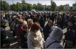  ?? EVGENIY MALOLETKA — THE ASSOCIATED PRESS ?? People stand in line for registrati­on at the aid distributi­on center for displaced people in Zaporizhia, Ukraine, on Thursday.