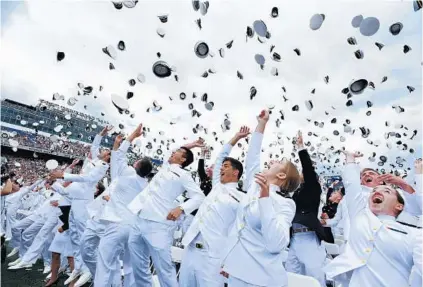  ?? PAUL W. GILLESPIE/BALTIMORE SUN MEDIA GROUP ?? Jubilant members of the Class of 2017 toss their caps in the air to mark the end of their time at the Naval Academy. Most of the 1,053 graduating midshipmen received commission­s as officers in the Navy or Marine Corps and will begin their military...