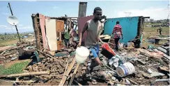 ??  ?? Mthuleni Langa removes family belongings from their eMpolweni house, which was destroyed by the tornado.