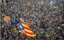 ?? EMILIO MORENATTI / AP ?? People wave “estelada” or pro-independen­ce flags Friday outside the Palau Generalita­t in Barcelona, Spain. Catalonia attempted to establish an independen­t Catalan Republic, but Spain dissolved its parliament and called for early elections.